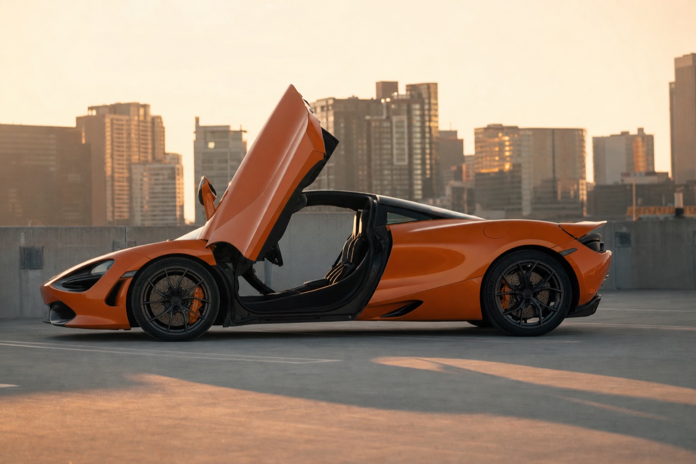 Rent a McLaren: an orange McLaren 720S with its dihedral door open on a rooftop car park at golden hour