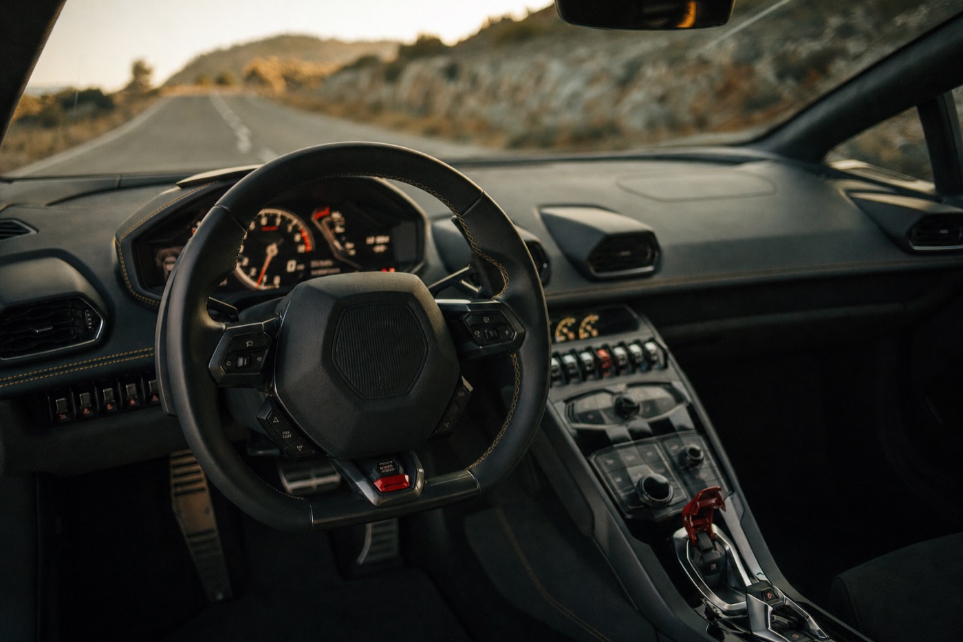 Tips for driving a Lamborghini Huracán: the cockpit and drive-mode selector of a Huracán looking out at an empty road