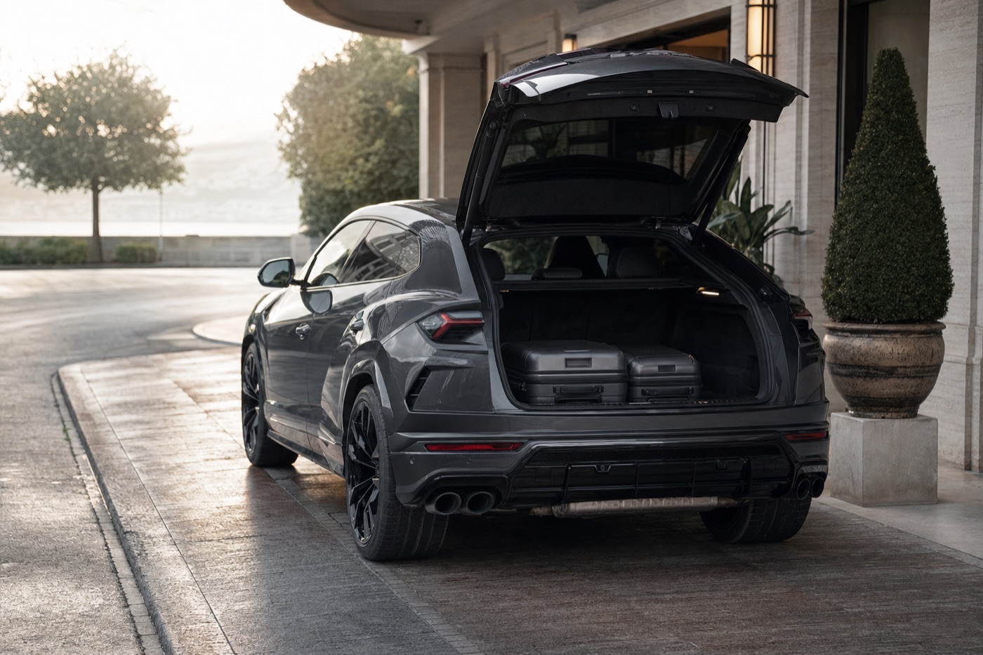 Choosing between a Huracán and an Urus by passengers and luggage: a Lamborghini Urus with the tailgate open at a hotel kerb