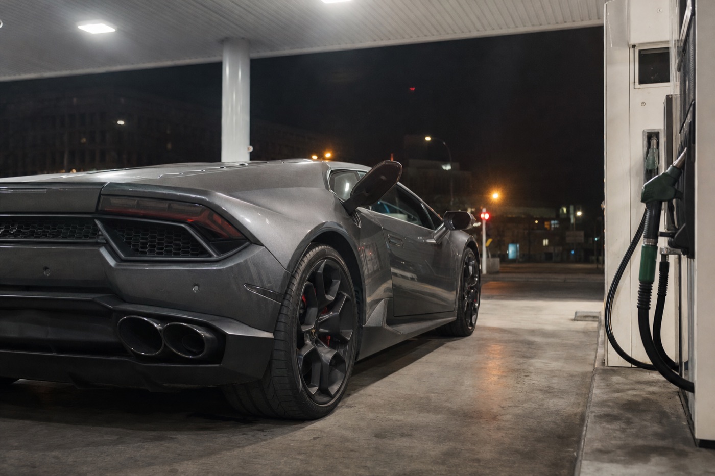 Total cost of a three-day Lamborghini rental: a Huracán at a fuel station at night with the fuel flap open